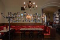 Red booth inside cafe Eiles with framed photographs hung on wall above the booth